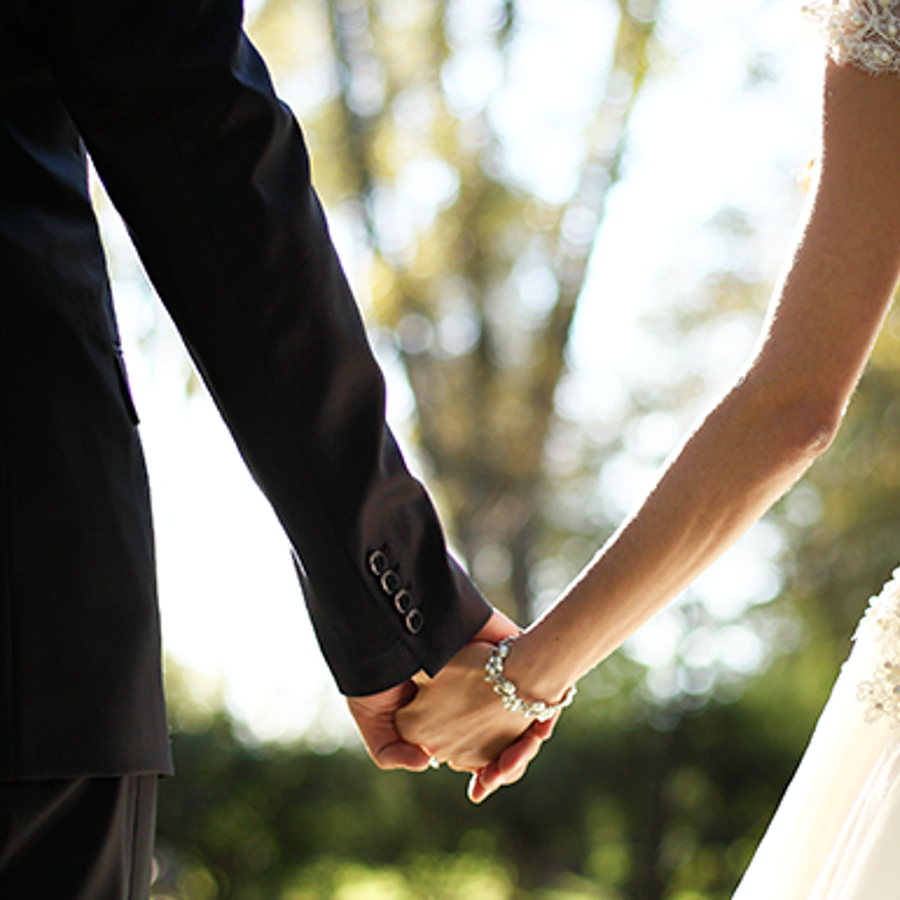 Wedding couple holding hands.