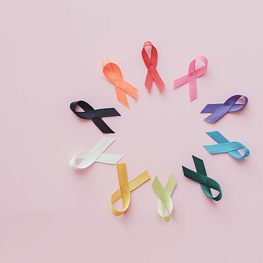 Cancer awareness ribbons placed on a pink background.