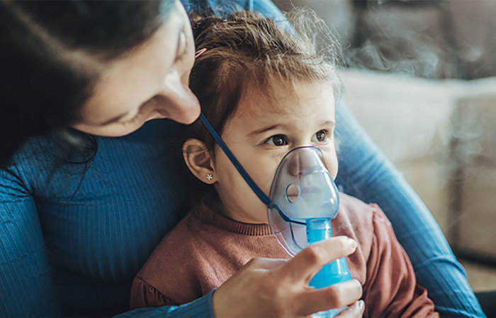 Mother with her daughter using an inhaler.