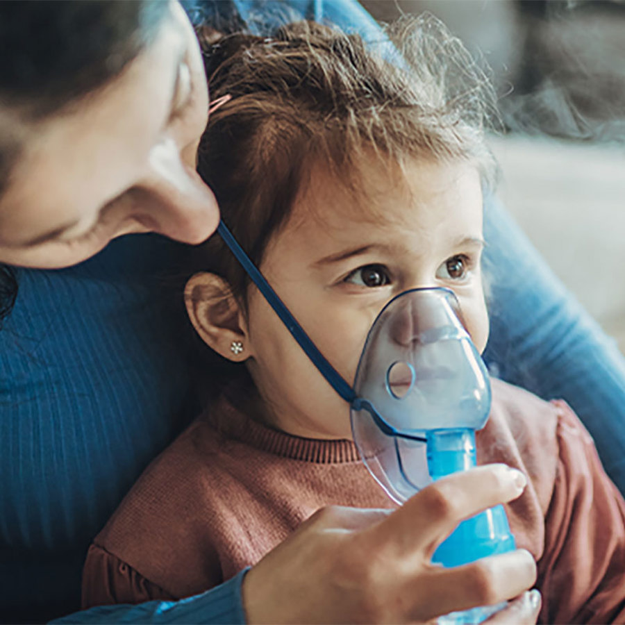 Mother with her daughter using an inhaler.