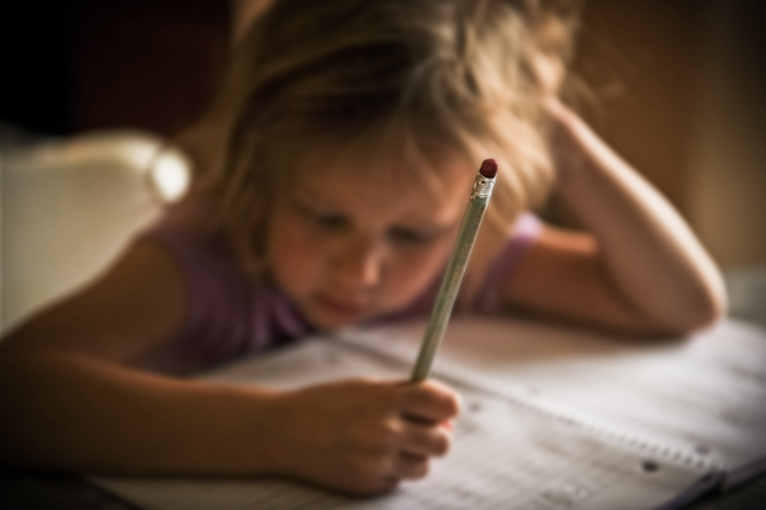 Girl writing with a pencil.