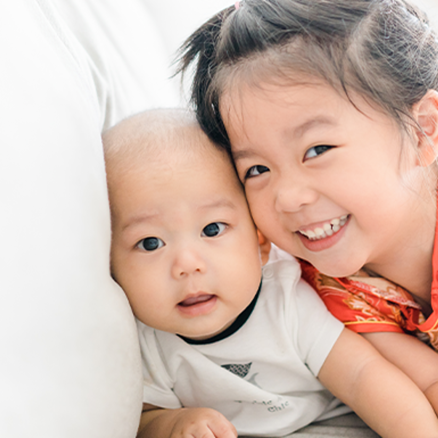 Little sister hugging her baby brother.