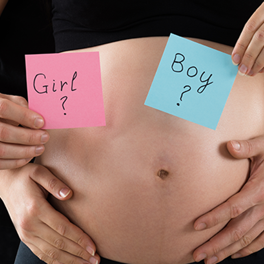 Young couple expecting with a close-up on their mid section.