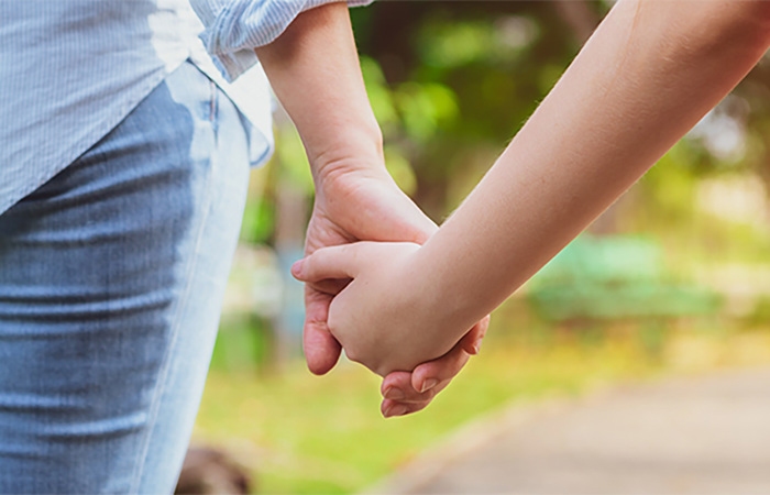 Relaxed happy mother holding hands with little daughter.