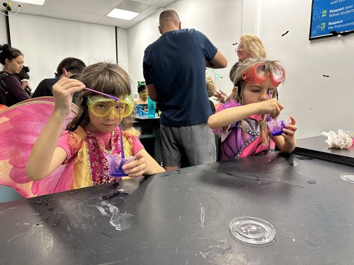 Two girls in fairy costumes make slime