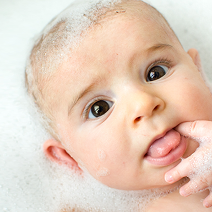 Newborn baby having a bubble bath.