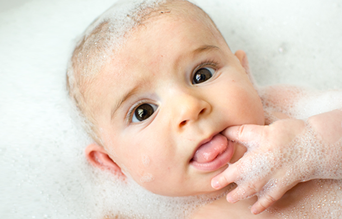 Newborn baby having a bubble bath.