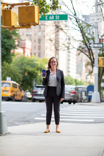 Tracy Dennis stands in Manhattan with her phone.