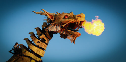 A man made dragon contraption breathing fire.