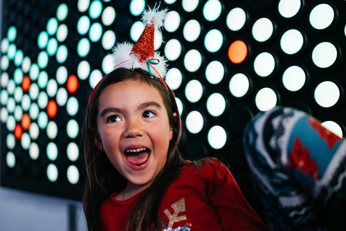 Girl smiling in Santa hat inside The Tech Interactive
