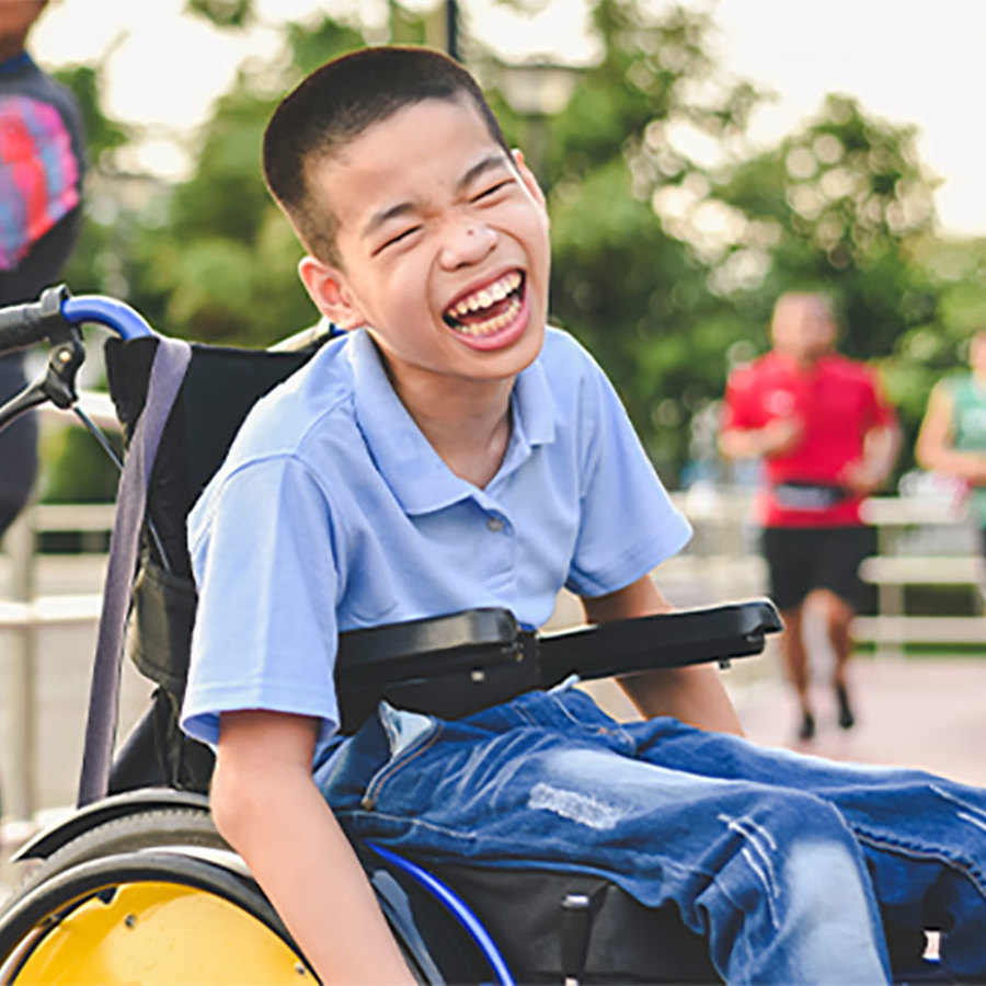 Child in wheelchair outdoors.