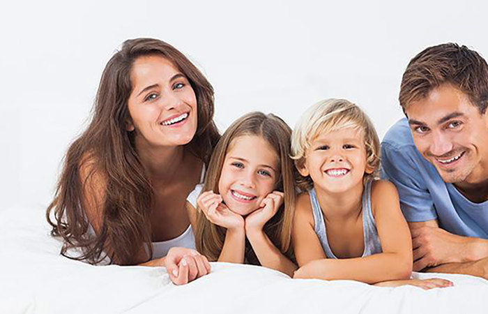 Family smiling while lying down.