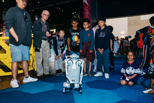 children gather around an AI-powered robot dog at The Tech Interactive