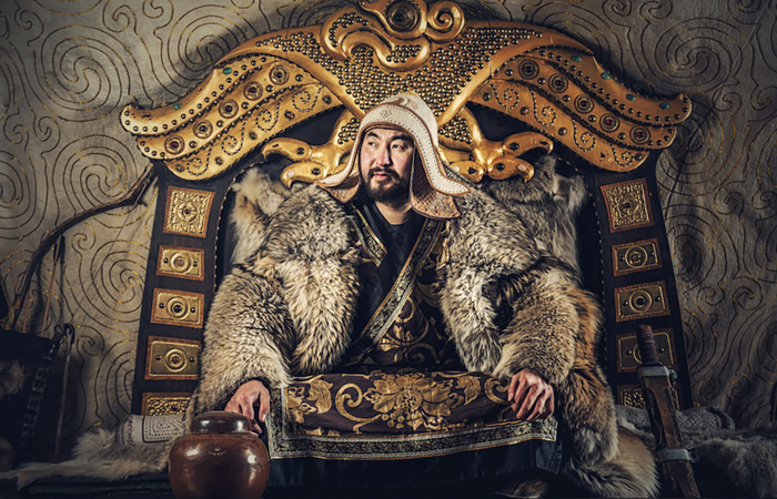 Genghis Khan sitting at his throne.