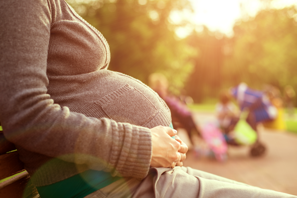 Pregnant woman sitting in park.