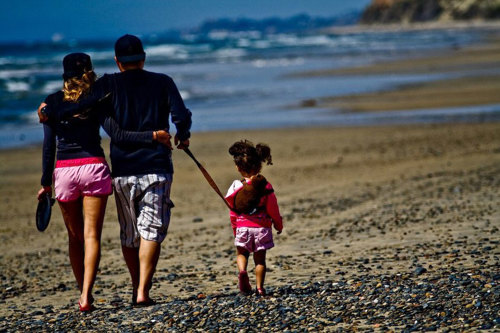 Two adults and a child on the beach.