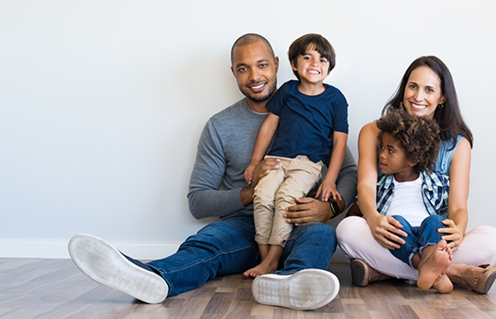 Happy multi-ethnic family sitting together on floor.