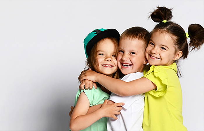 A group of children smiling and hugging.