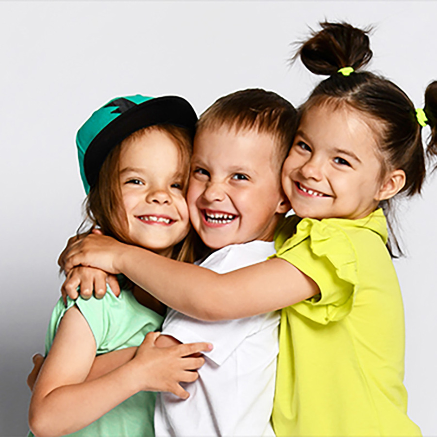 A group of children smiling and hugging.