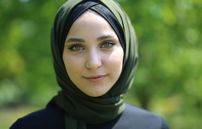 Green-eyed woman wearing a green hijab.