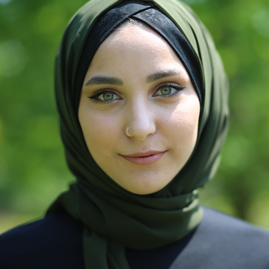 Green-eyed woman wearing a green hijab.